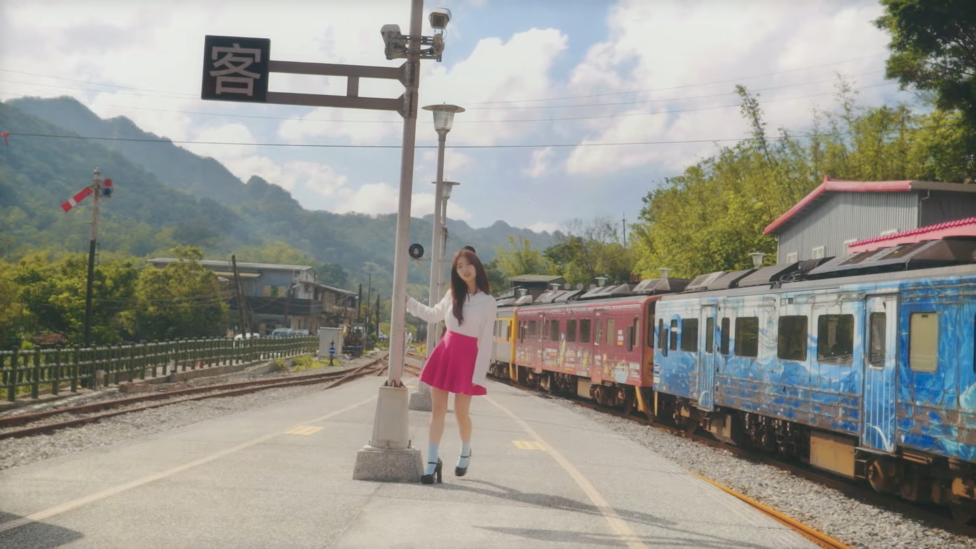 Yeojin standing by a train.